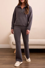 Load image into Gallery viewer, Woman wearing a gray casual zip up top, matching gray jogger and sneakers standing in a room with a beige couch.

