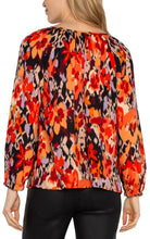 Load image into Gallery viewer, Experience the allure of nature with our elegant long-sleeve shirred woven blouse, featuring a lively burnt orange floral print. Made from a delicate woven fabric, this blouse flows beautifully, providing comfort and allowing breathability. This vibrant color top features long sleeves, ideal for day-to-evening wear, and its loose fit guarantees freedom of movement for lasting comfort.
