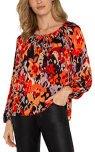 Load image into Gallery viewer, Experience the allure of nature with our elegant long-sleeve shirred woven blouse, featuring a lively burnt orange floral print. Made from a delicate woven fabric, this blouse flows beautifully, providing comfort and allowing breathability. This vibrant color top features long sleeves, ideal for day-to-evening wear, and its loose fit guarantees freedom of movement for lasting comfort.
