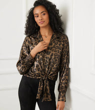 Load image into Gallery viewer, Woman wearing a leopard print shirt and black pants standing against a white wall.
