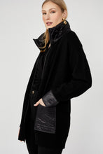 Load image into Gallery viewer, Woman wearing a long black jacket with rhinestone zipper and black leather leggings against a white background.
