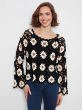 Load image into Gallery viewer, A woman wearing a black crochet long-sleeve top with a white daisy pattern, paired with blue jeans, against a plain light gray background.

