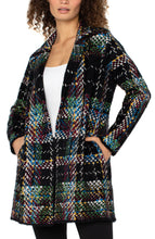 Load image into Gallery viewer, Woman wearing a multicolored patterned coatigan over a white tank and black pants against a white background.
