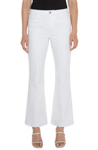 Load image into Gallery viewer, Model wearing white denim bootcut jeans with welt pockets, white sandals and black top against a white background.

