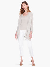 Load image into Gallery viewer, Worn open or tied at the front, this lightweight relaxed-fit cardigan brings draped comfort and style to any outfit. Designed to sit slightly below the hip with an 3/4 length sleeves. Made with a soft, breathable T-shirt yarn with metallic lurex added in to give it just the right amount of shine.  Color- Light sand. Subtle sparkle throughout. Cape design. Lurex yarn, wear open or tied. Lightweight.
