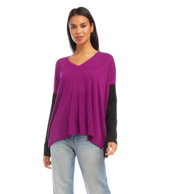 A modern look is achieved through the color blocked panels in this jersey-knit top. It's ideal for casual days, combining warmth and fashion. This top pairs well with any denim.  Color- Magenta and black. Colorblock design. Long sleeve. Hi-low hem. Side-slits. Heavy Rayon Spandex: 90% Rayon. 10% Spandex. Care - Machine wash separately cold water or dry clean.
