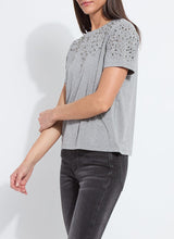 Load image into Gallery viewer, Model wearing a rhinestone embellished dark grey, short sleeve top and grey jeans against a white background.
