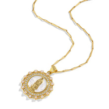 Load image into Gallery viewer, Gold necklace with a round pendant with pearls and crystals surrounding a white pearl shell with a gold Virgin Mary icon against a white background.
