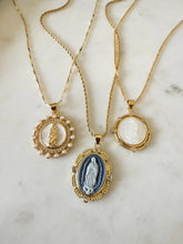 Load image into Gallery viewer, Three gold necklaces with pendant designs on a marble surface.

