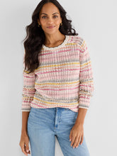 Load image into Gallery viewer, Woman wearing a colorful sweater and blue jeans against a white background.
