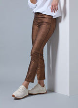 Load image into Gallery viewer, Crafted with a concealed patented waistband, beltloops, and hem slits adorned with gunmetal studs, the Melina Metallic Coated Straight Denim boasts an ankle-length fit. The 4x-stretch Knit Denim fabric is coated with a no-odor Polyurethane, offering the look and feel of vegan leather while retaining the same characteristics as our classic knit denim. These jeans feature a slim, fitted waist and hip, and a timeless straight leg silhouette that falls just at the ankle.
