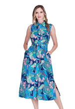 Load image into Gallery viewer, Woman wearing a blue, green and coral floral long sleeveless dress with a slit against a white background.
