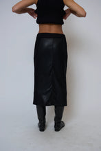 Load image into Gallery viewer, Model wearing a black long skirt and black boots against a white background.
