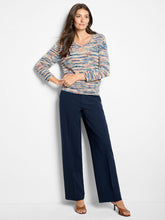 Load image into Gallery viewer, Woman wearing a patterned sweater, navy pants and brown heels against a white background.
