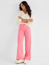 Load image into Gallery viewer, Woman wearing a cream sweater with pastel abstract print, pink pants and white sneakers against a white background.
