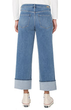 Load image into Gallery viewer, Model wearing cuffed blue jeans, white top and white high-top sneakers against a white background.
