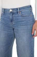 Load image into Gallery viewer, A close-up of model wearing blue jeans and white top.
