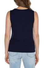 Load image into Gallery viewer, Woman wearing a navy sleeveless ribbed tank and blue jeans against a white background.
