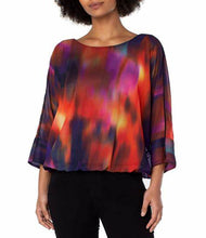 Load image into Gallery viewer, Featuring mesmerizing northern lights print in red, purple/blue, yellow and black, this top is sure to turn heads. Its dolman sleeves and tie back detail add to its charm — perfect for brunch or special occasions, it looks great when paired with denim or trousers.  `Colors-Northern lights - Splashes of red, purple/blue, yellow and black. Chiffon fabrication Round neckline. 3/4 dolman sleeves. Northern light print. Tie back detail. Gathered hemline.
