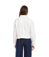 Load image into Gallery viewer, Woman wearing a white jacket and dark blue jeans on a white background.
