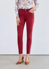Load image into Gallery viewer, Woman wearing a floral blouse, red slim ankle jeans and brown heels against a white background.
