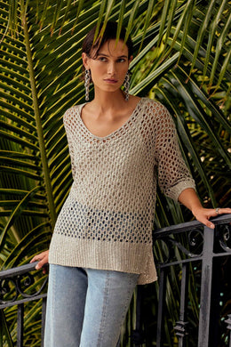 Enhance your wardrobe with a stylish and elegant top that features mini sequins and an open stitch design. Made with an acrylic blend knit, this sweater adds a touch of sparkle to any outfit and boasts a relaxed fit with drop shoulders, three-quarter sleeves, and side slits for maximum comfort.  Color- Champagne. Sweater knit. V-neckline. Three-quarter sleeves. Adorned with mini sequins.