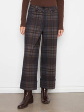 Load image into Gallery viewer, A person wearing dark brown plaid wide-leg trousers with a brown long-sleeve top and dark brown ankle boots, standing against a white wall.
