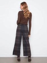 Load image into Gallery viewer, A woman is shown from the back wearing a brown long-sleeve top and dark plaid wide-leg trousers, standing against a plain white wall.
