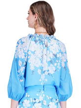 Load image into Gallery viewer, Woman wearing a blue floral outfit on a white background.
