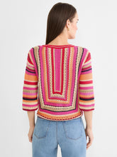 Load image into Gallery viewer, Woman wearing a red multicolor striped three-quarter sleeve sweater and blue jeans against a light grey background.
