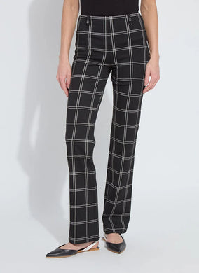 Model wearing black and off-white plaid pants and black flats standing against a white background.