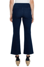 Load image into Gallery viewer, Model wearing dark blue ankle flare, pull on denim and black high heeled sandals against a white background.
