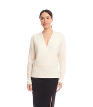 Load image into Gallery viewer, Woman wearing a cream v-neck  sweater with pearls and black skirt against a white background.
