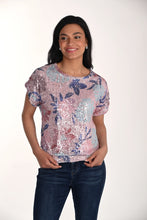 Load image into Gallery viewer, Woman wearing a sequined top with a floral pattern and blue jeans on a white background.
