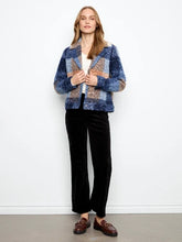 Load image into Gallery viewer, A woman modeling a boucle plaid short coat with blue, beige, and orange sections, worn over a white top, black pants and loafers against a plain white background.
