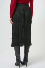 Load image into Gallery viewer, Close-up of model wearing a tiered fringe black long skirt and red cardigan against a light background.
