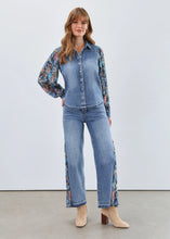 Load image into Gallery viewer, Woman in denim shacket with floral sleeves, jeans with floral side inserts and tan boots against a white background.
