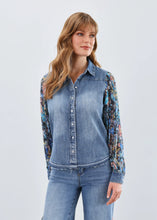 Load image into Gallery viewer, Woman wearing a denim shirt with floral sleeves and jeans against a white background.
