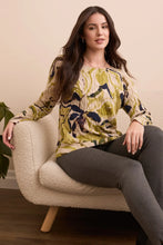 Load image into Gallery viewer, Woman sitting on a beige armchair wearing a floral sweater and grey pants.
