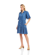 Load image into Gallery viewer, Woman wearing a blue chambray dress and sandals standing against a white background.
