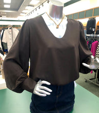 Load image into Gallery viewer, Mannequin wearing a brown blouse with a store interior background.
