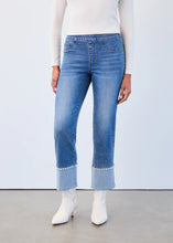 Load image into Gallery viewer, Model wearing a white top, blue jeans with pearl embellished cuffs and white boots against a white wall.
