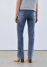 Load image into Gallery viewer, Woman wearing a light blue short sleeve sweater, blue jeans and beige boots against a white background.
