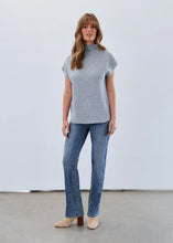 Load image into Gallery viewer, Woman wearing a light blue short sleeve sweater, blue jeans and beige boots against a white background.
