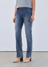 Load image into Gallery viewer, Woman wearing a light blue short sleeve sweater, blue jeans and beige boots against a white background.
