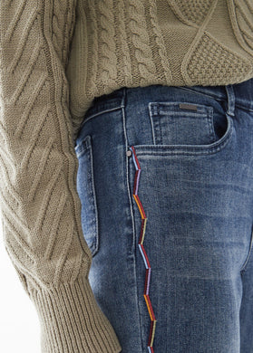 This Indigo Wash Jean with Multicolor Embroidery is the perfect addition to elevate your denim look. It features a pull-on style, faux-fly stitching, 5-pocket styling, belt loops, and a slim leg taper that can be unrolled for full length. Zig zag embroidery decorates the outer seams. Color- Indigo wash. Zig Zag embroidery colors- light blue, light orange, dark red. Pull-on style. Faux fly stitching. Five functional pockets. Zig Zag embroidery down each side. Belt loops.