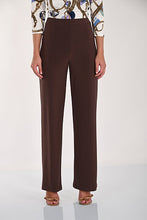 Load image into Gallery viewer, A model is wearing a pair of dark brown straight-leg trousers, paired with a patterned top and nude sandals, standing against a plain white studio background.
