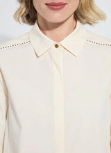 Load image into Gallery viewer, Close-up of a model wearing a cream-colored blouse with a collar and bronze embellishment details.
