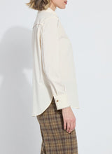 Load image into Gallery viewer, Model wearing a cream-colored long sleeve blouse with bronze embellishments and brown plaid pants against a white background.
