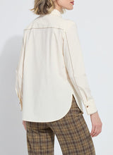 Load image into Gallery viewer, Model wearing a cream-colored long sleeve blouse with bronze embellishments and brown plaid pants against a white background.
